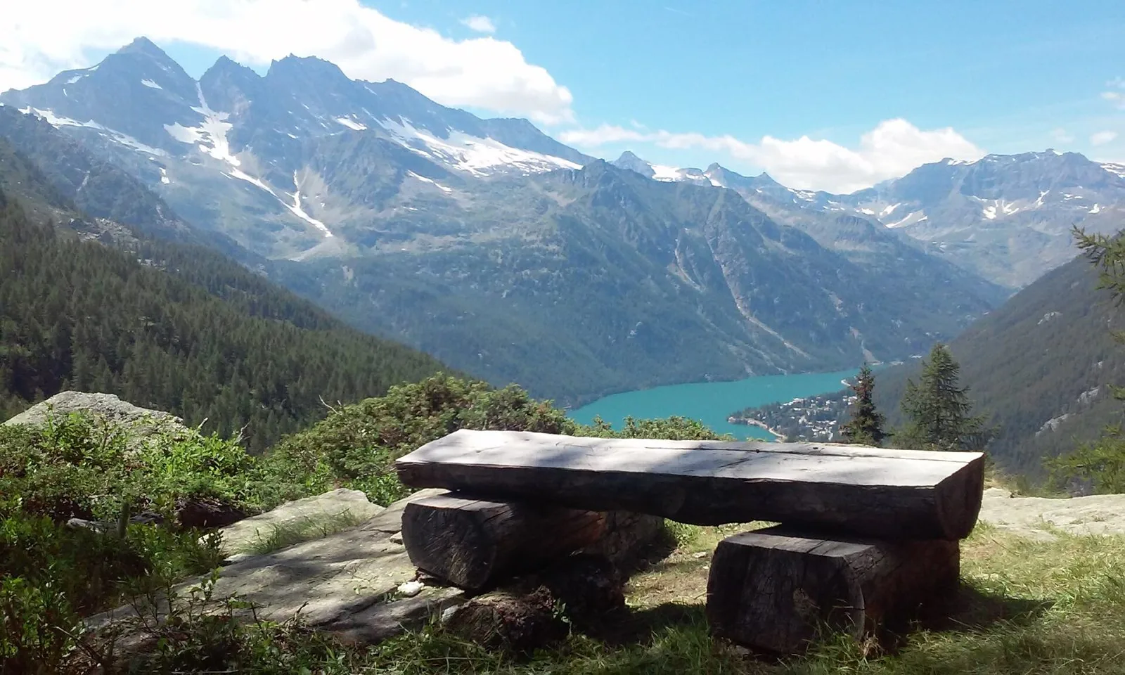 Panchina in legno affacciata sul lago di Ceresole Reale con le vette del Gran Paradiso sullo sfondo